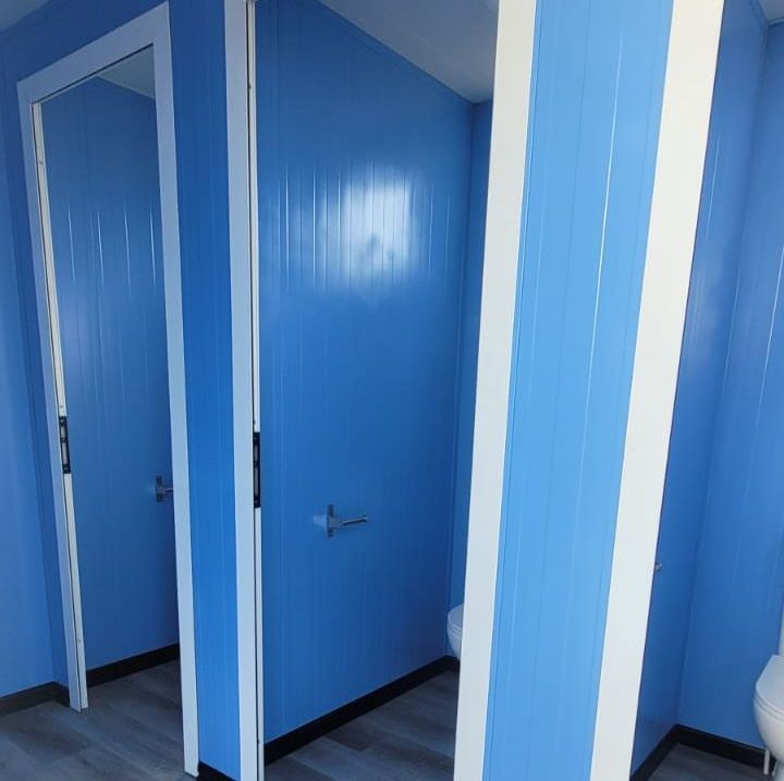 Un baño con paredes azules y un inodoro.