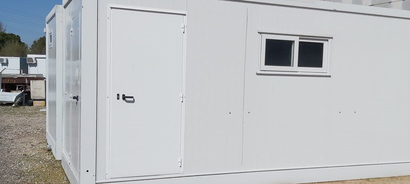 Un edificio blanco con dos ventanas y una puerta.