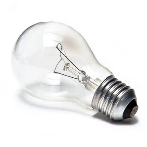 Klare Glühbirne, silberner Sockel, auf einer weißen Oberfläche liegend.