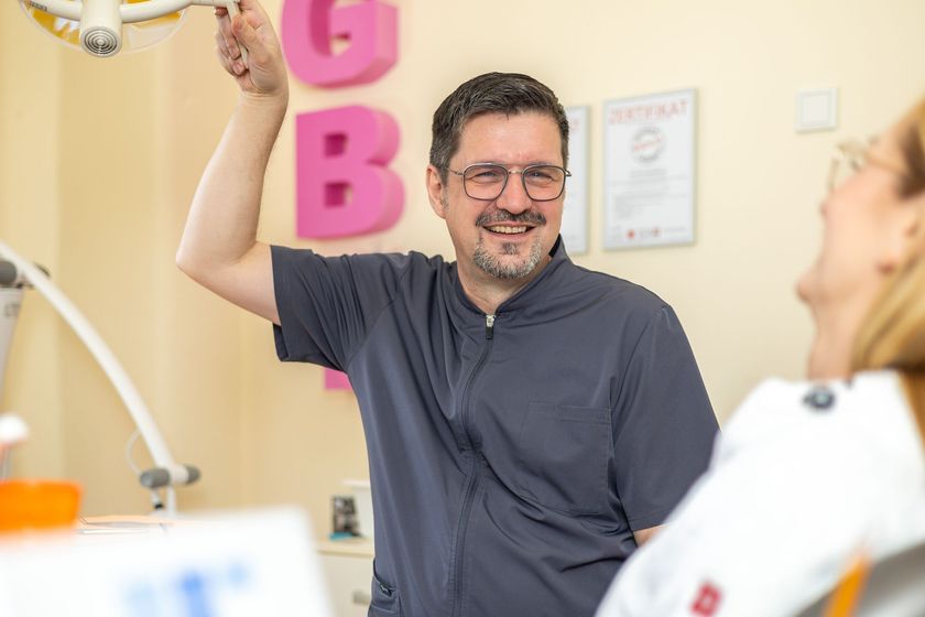 Zahnarzt Kai Hopp, Inhaber der Zahnarztpraxis in Duisburg, lächelt in seiner Behandlungspraxis.