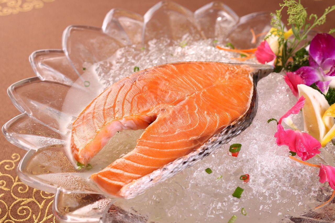 Un trozo de salmón reposa sobre hielo en un plato.