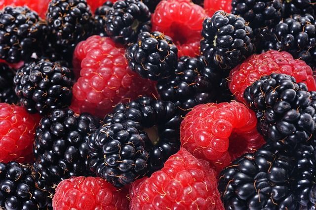 Un primer plano de frambuesas y moras sobre una mesa.