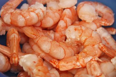 Un montón de camarones cocidos en un recipiente azul.