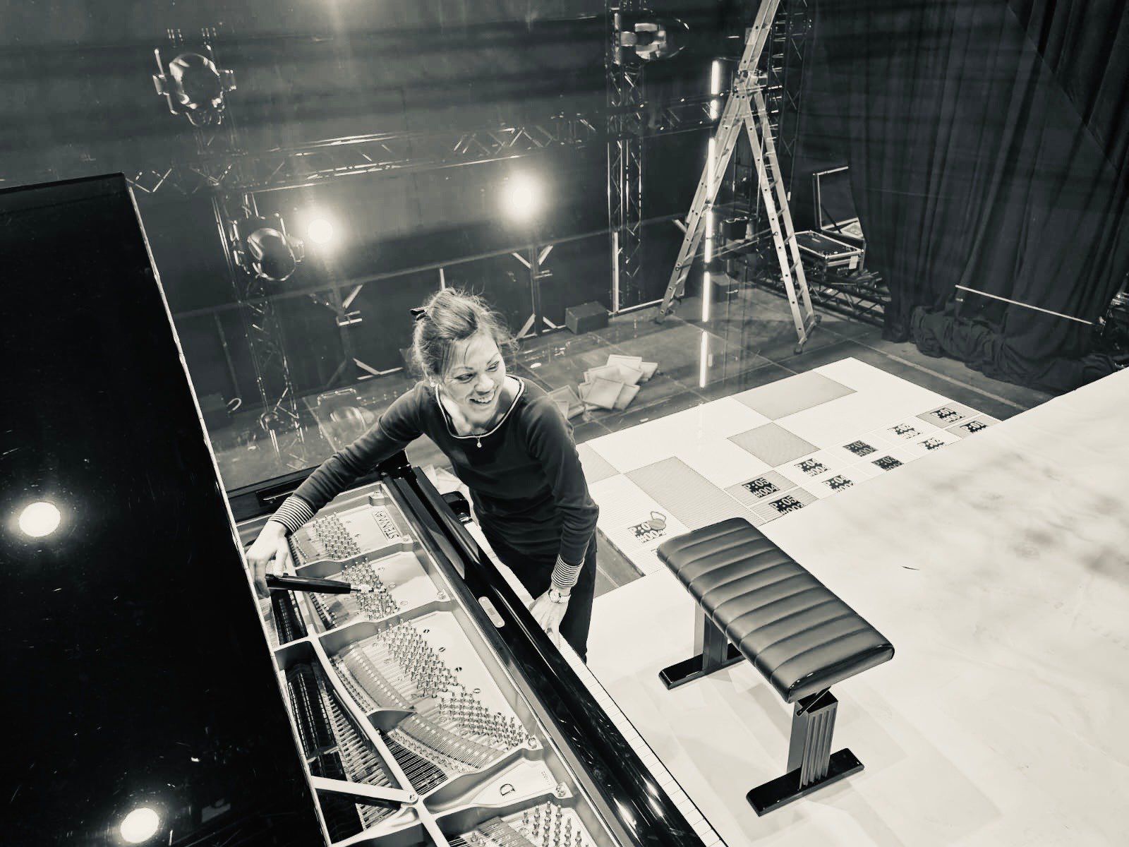 Irena Nakajima-Daum stimmt einen Konzertflügel im Bühnenhintergrund mit Leichtigkeit