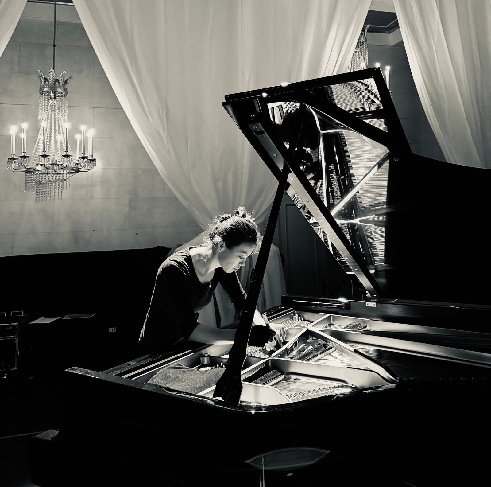 Irena Nakajima-Daum stimmt einen Flügel in stilvoller Umgebung mit Kronleuchter