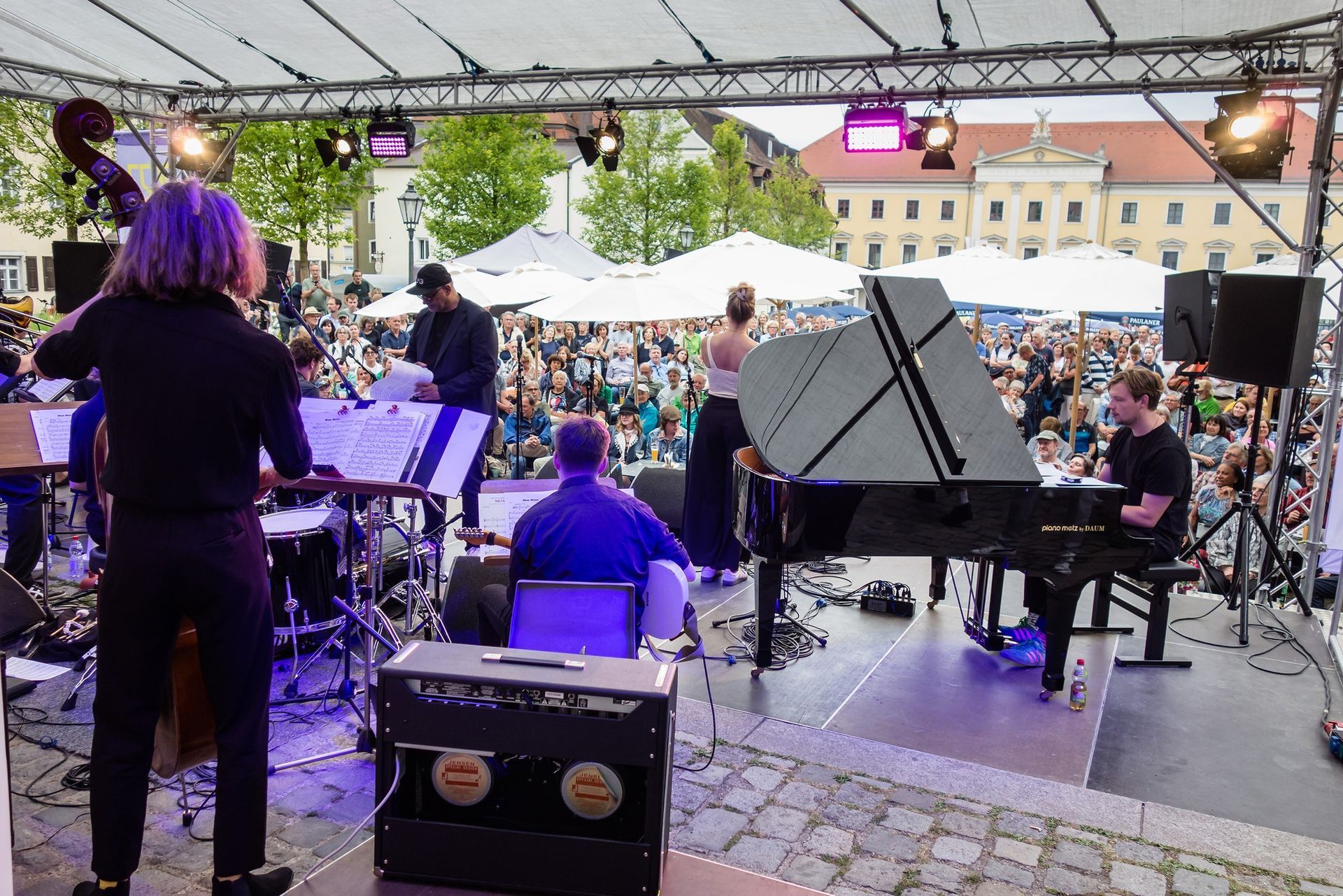 Open-Air-Konzert mit großem Ensemble und Flügel von Piano Metz by DAUM beim Jazzweekend Regensburg 2025 – Blick von der Bühne ins Publikum