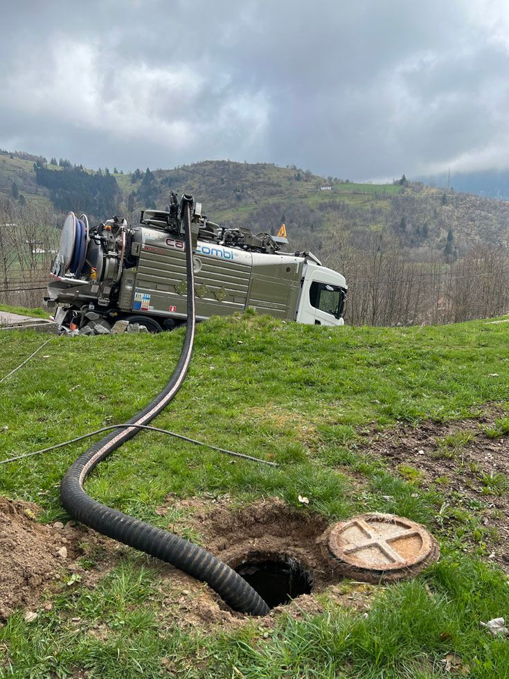 camion de MBJ assainissement avec pompage en cours avec Paysage des Vosges en arrière plan
