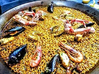 Una sartén grande llena de arroz y mariscos.