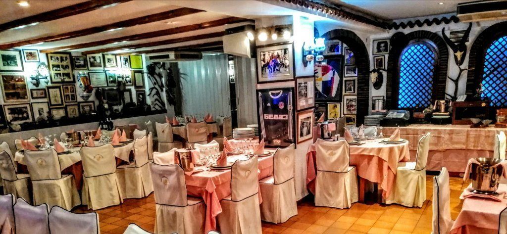 Una gran sala llena de mesas y sillas en un restaurante.