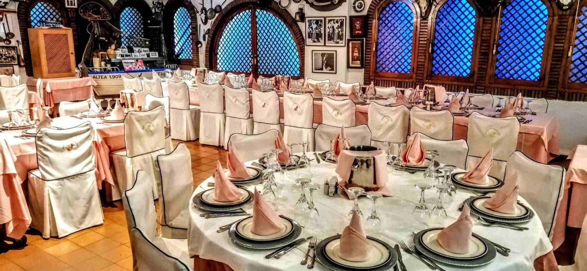 Un gran comedor con mesas y sillas preparadas para una recepción de boda.