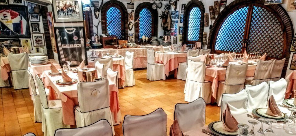 Un restaurante con mesas y sillas preparadas para un banquete.