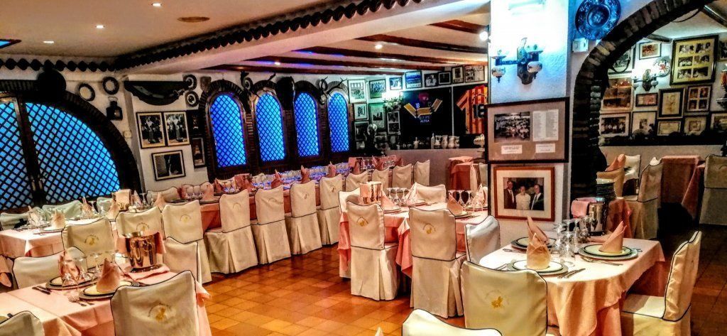 Un restaurante con mesas y sillas preparadas para un banquete.