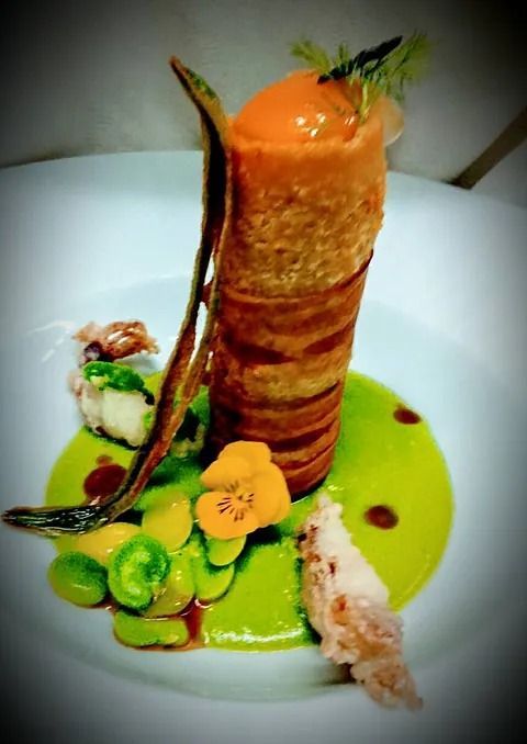 Un plato de comida con una zanahoria encima.