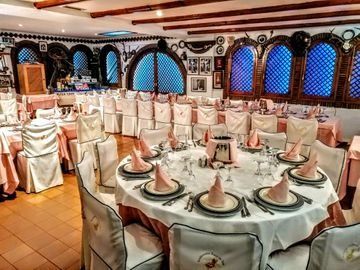 Un restaurante con mesas y sillas preparadas para un banquete.