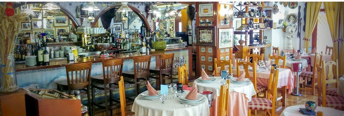 Un restaurante con mesas y sillas preparadas para una comida.