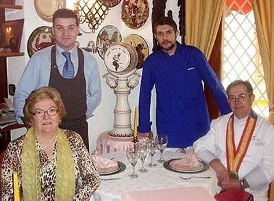 Un grupo de personas de pie alrededor de una mesa con platos encima.