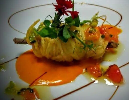 Un primer plano de un plato de comida con una flor encima.
