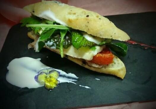 Un primer plano de un sándwich en un plato negro.