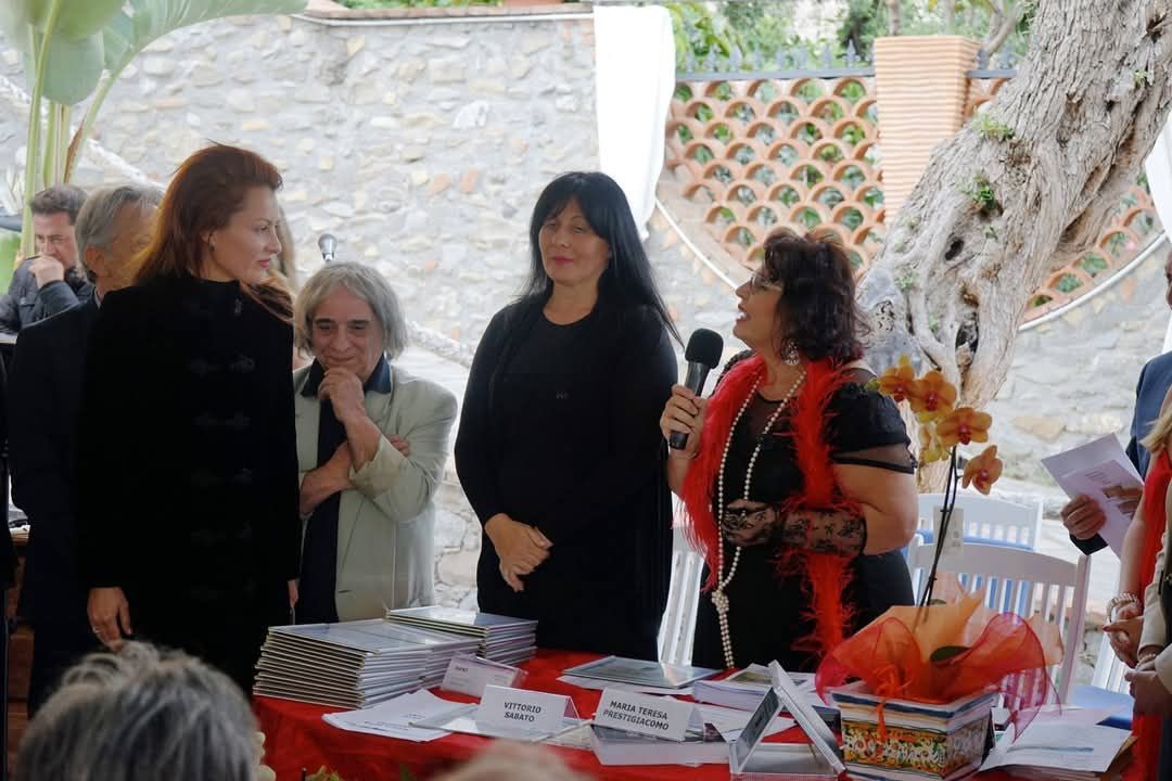 Un grupo de mujeres están de pie alrededor de una mesa con un micrófono.