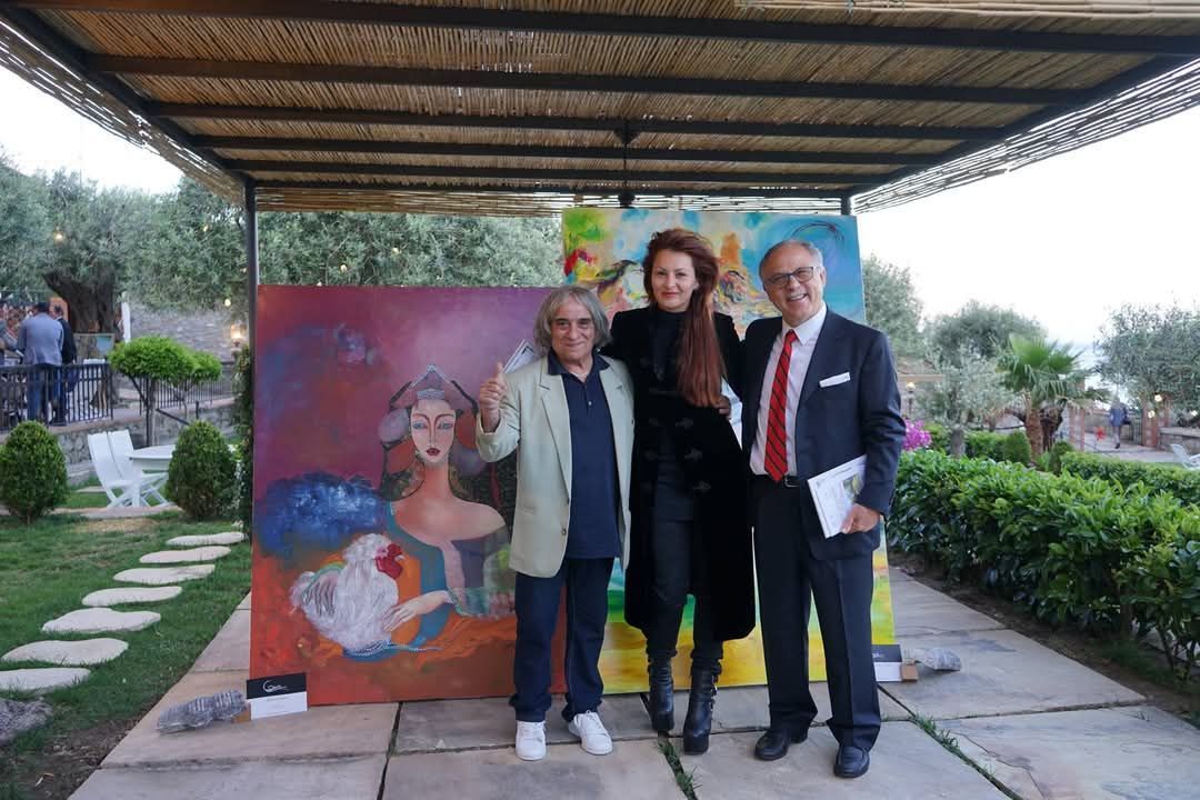 Tres personas posan para una fotografía delante de un cuadro.