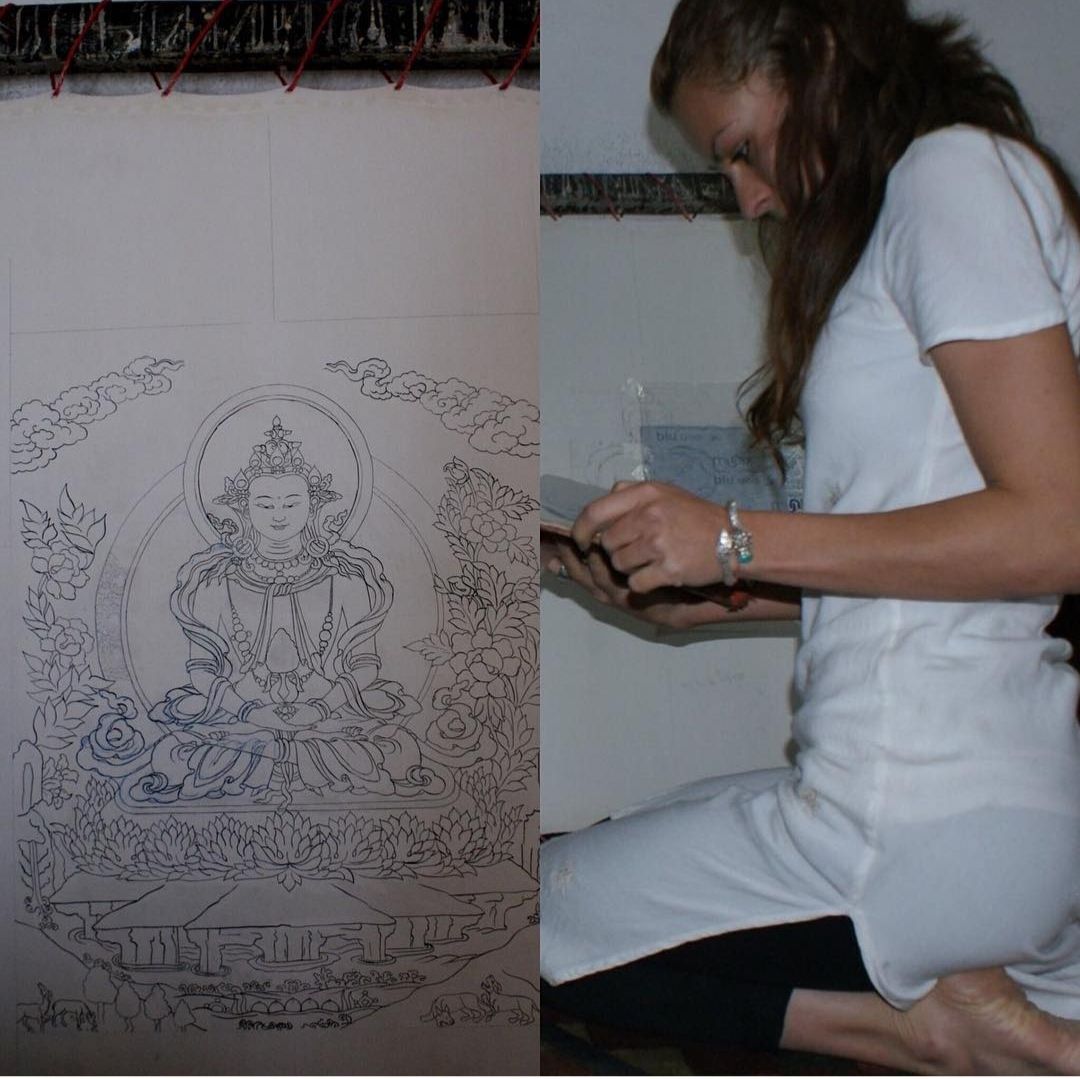 Una mujer está arrodillada frente a un dibujo de una mujer.