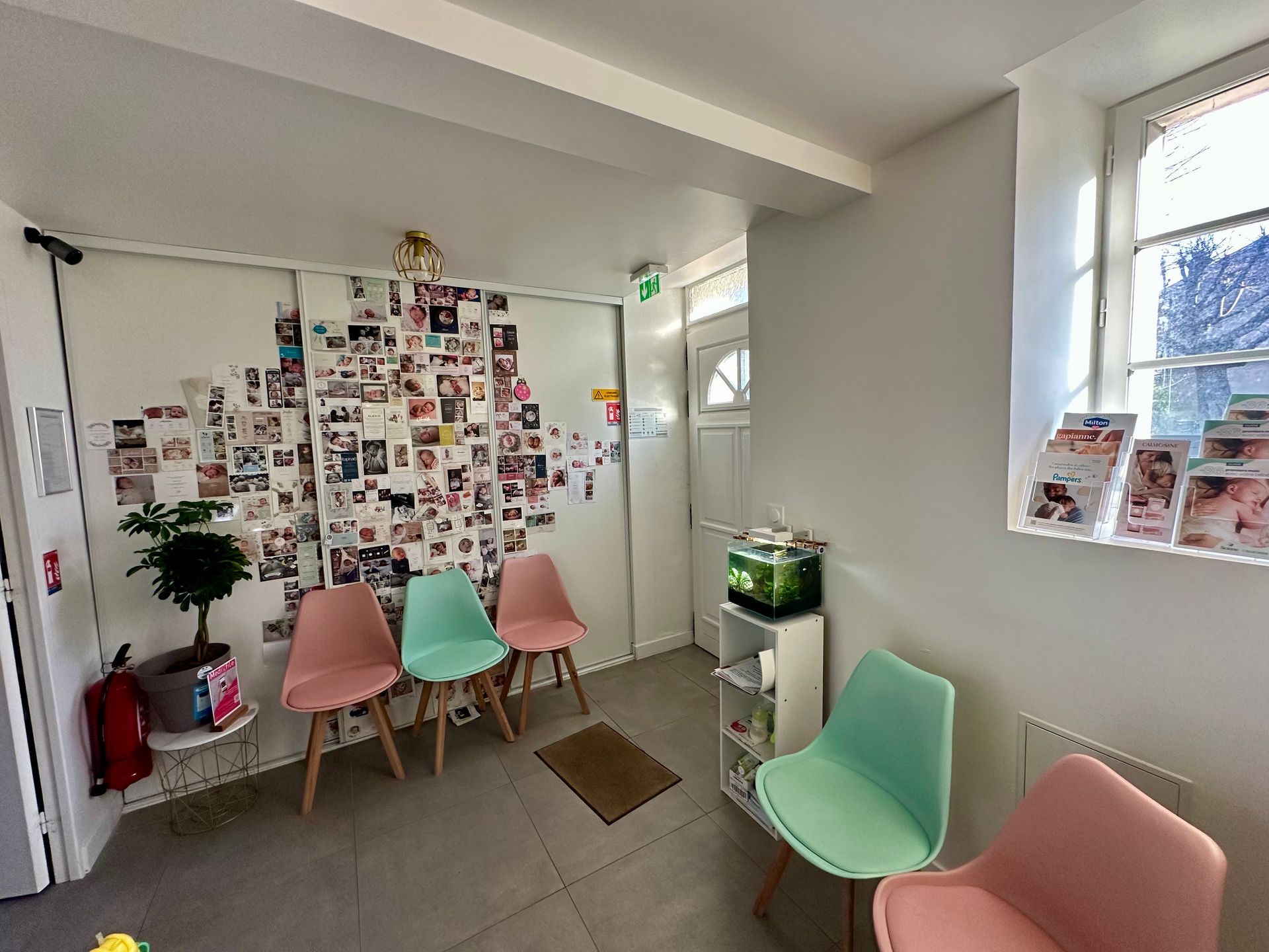 Une femme enceinte vêtue d'un blazer noir est assise en tailleur, les mains posées sur son ventre, dans un portrait de studio en noir et blanc.