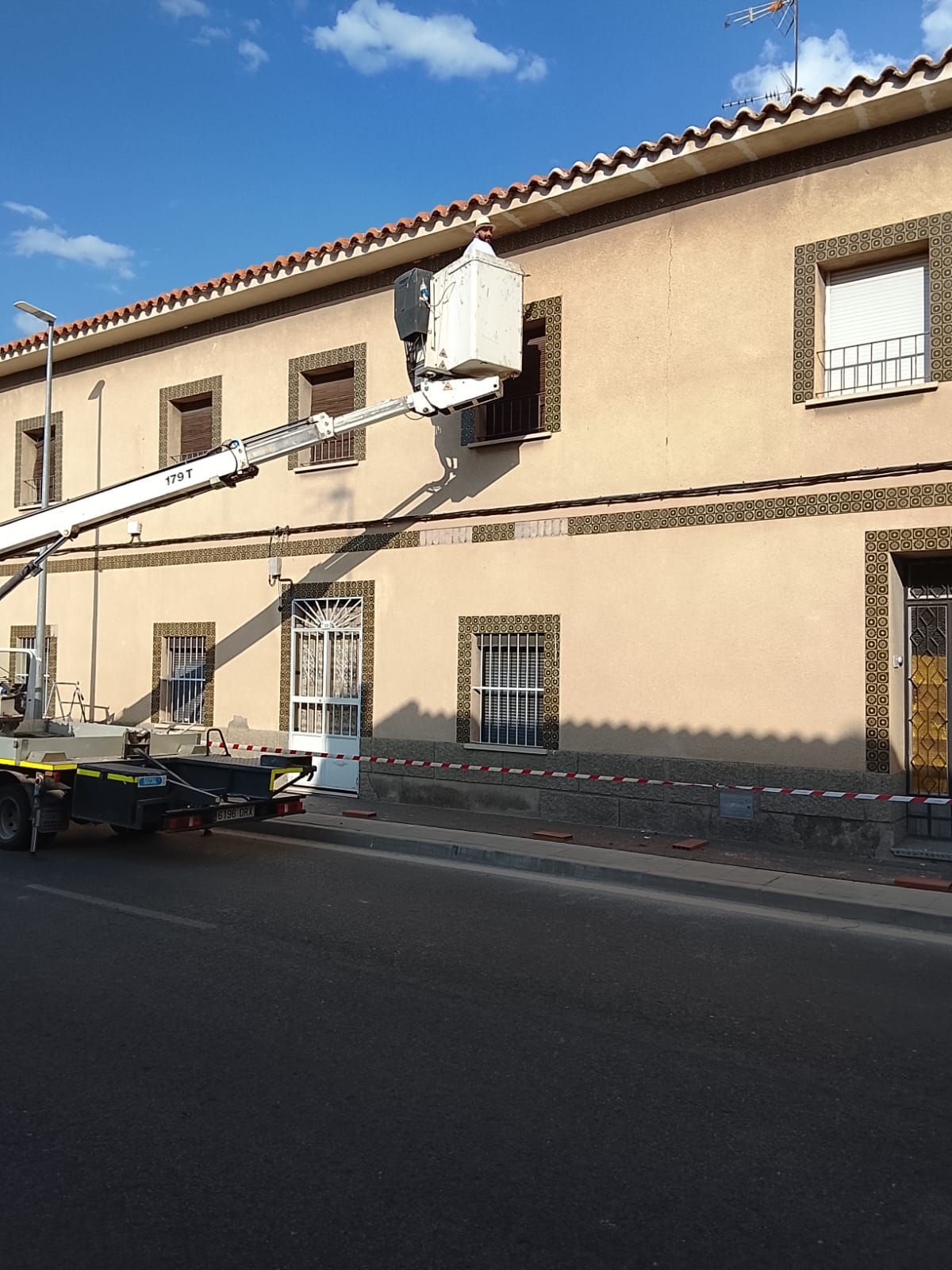 Limpiador de ventanas suspendido en un rascacielos, con equipo de seguridad. Iluminado por la dorada luz del sol.