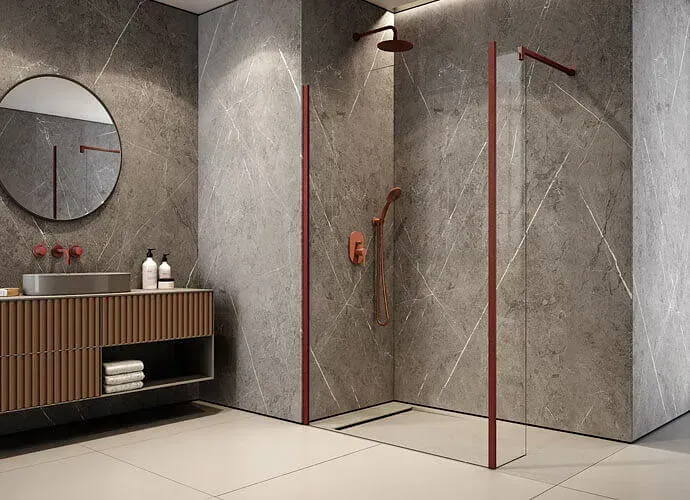 Baño con paredes de mármol gris, ducha con marco rojo, tocador de madera y espejo redondo.