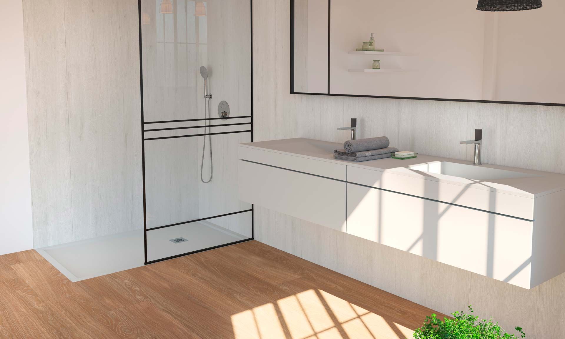 Plato de ducha gris oscuro con desagüe, junto a un panel de vidrio. Azulejos grises y blancos al fondo.