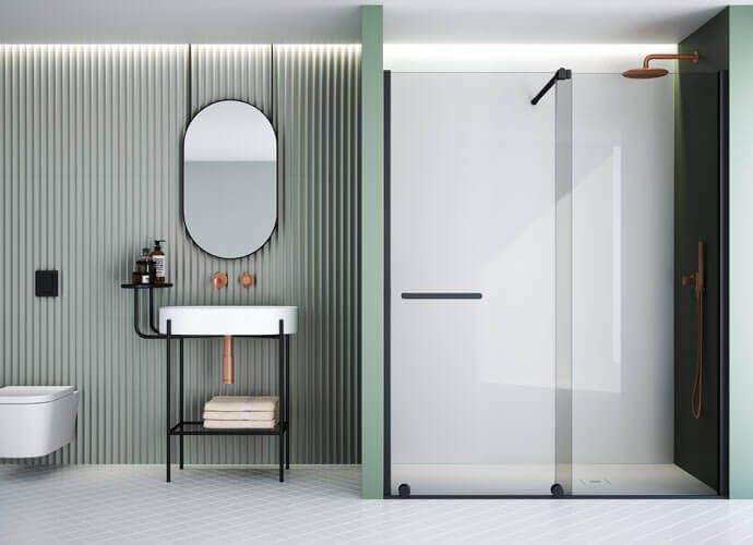 Baño moderno con paredes de color verde salvia, mampara de ducha negra y accesorios de cobre.