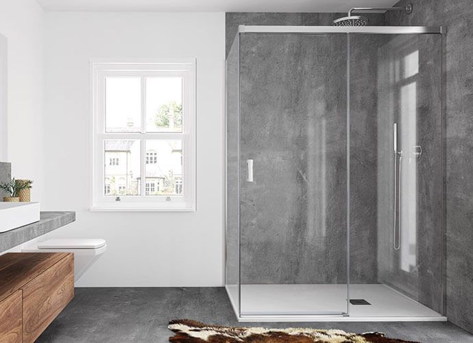 Baño moderno con ducha de cristal, paredes grises, accesorios blancos y tocador de madera.