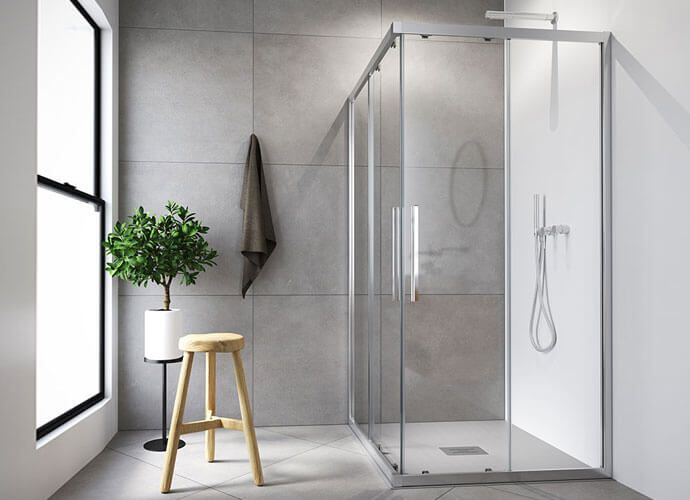 Baño moderno con ducha de cristal, taburete, planta y ventana. Paredes grises.