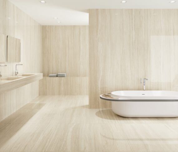 Baño moderno en tonos beige con bañera profunda y lavabo largo.