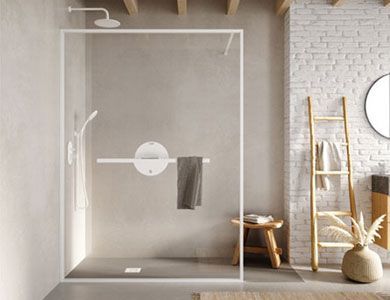 Baño moderno con ducha con mampara de cristal, toallero y ducha de mano. Tonos neutros y detalles en madera.