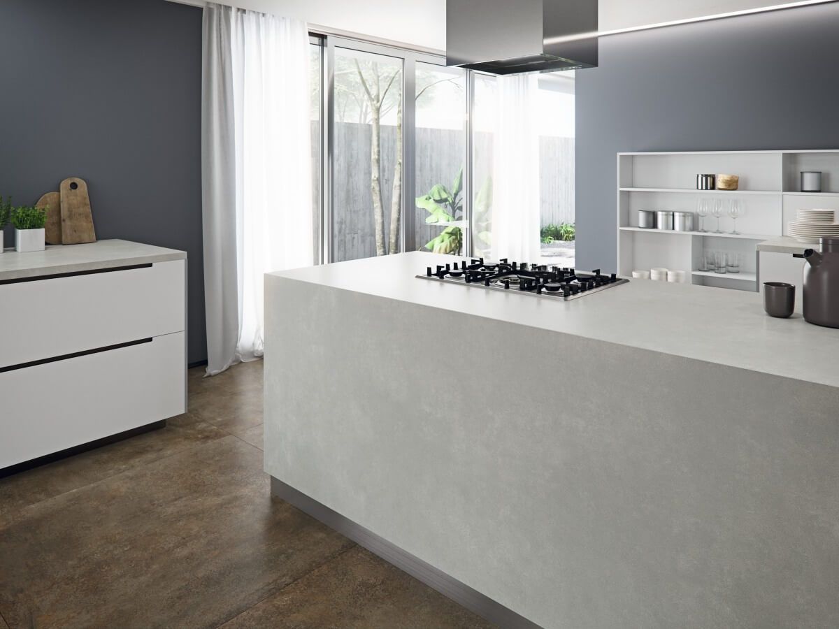 Cocina moderna con isla blanca, paredes grises y puertas de vidrio.