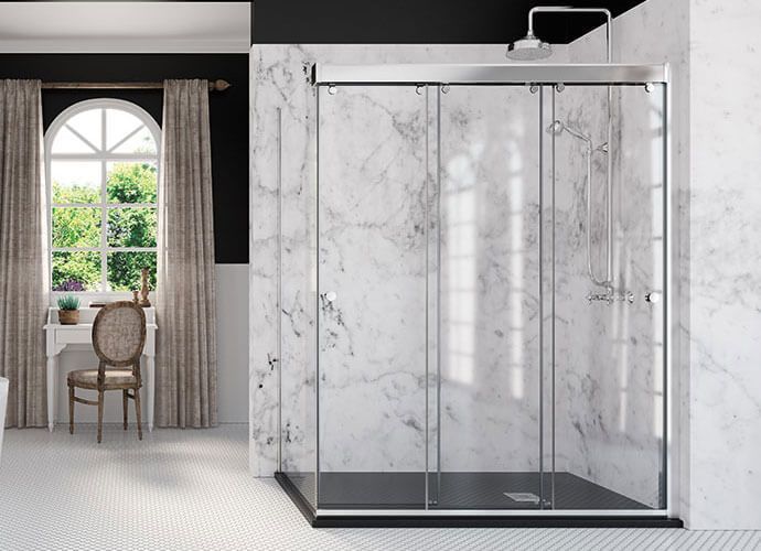 Mampara de ducha de cristal con puertas correderas en baño revestido de mármol.
