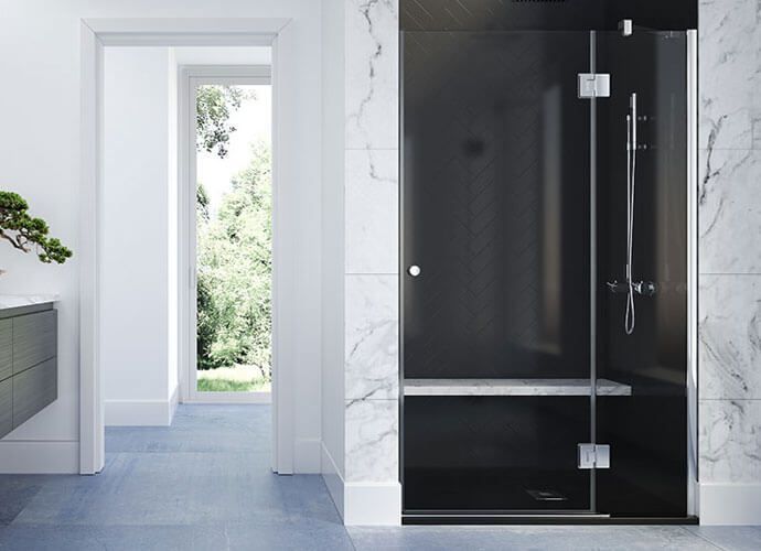 Baño moderno con cabina de ducha negra, detalles de mármol y puerta abierta a la vegetación.
