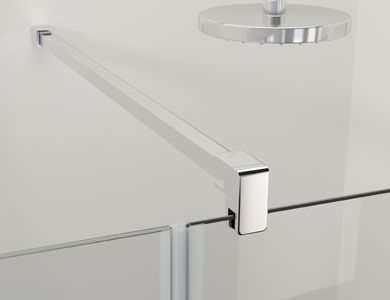 Manija cromada para puerta de ducha sobre panel de vidrio. Fondo gris, base de ducha blanca.