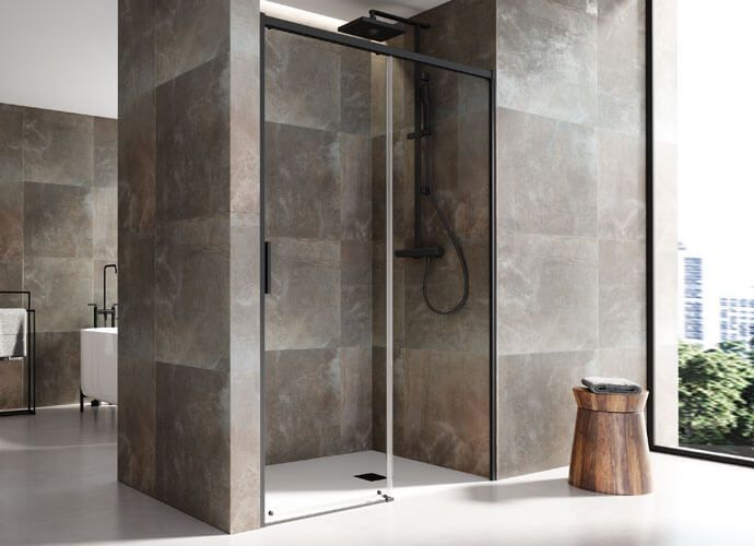 Ducha moderna con marco negro, puerta de cristal, paredes de azulejos oscuros y un pequeño taburete.