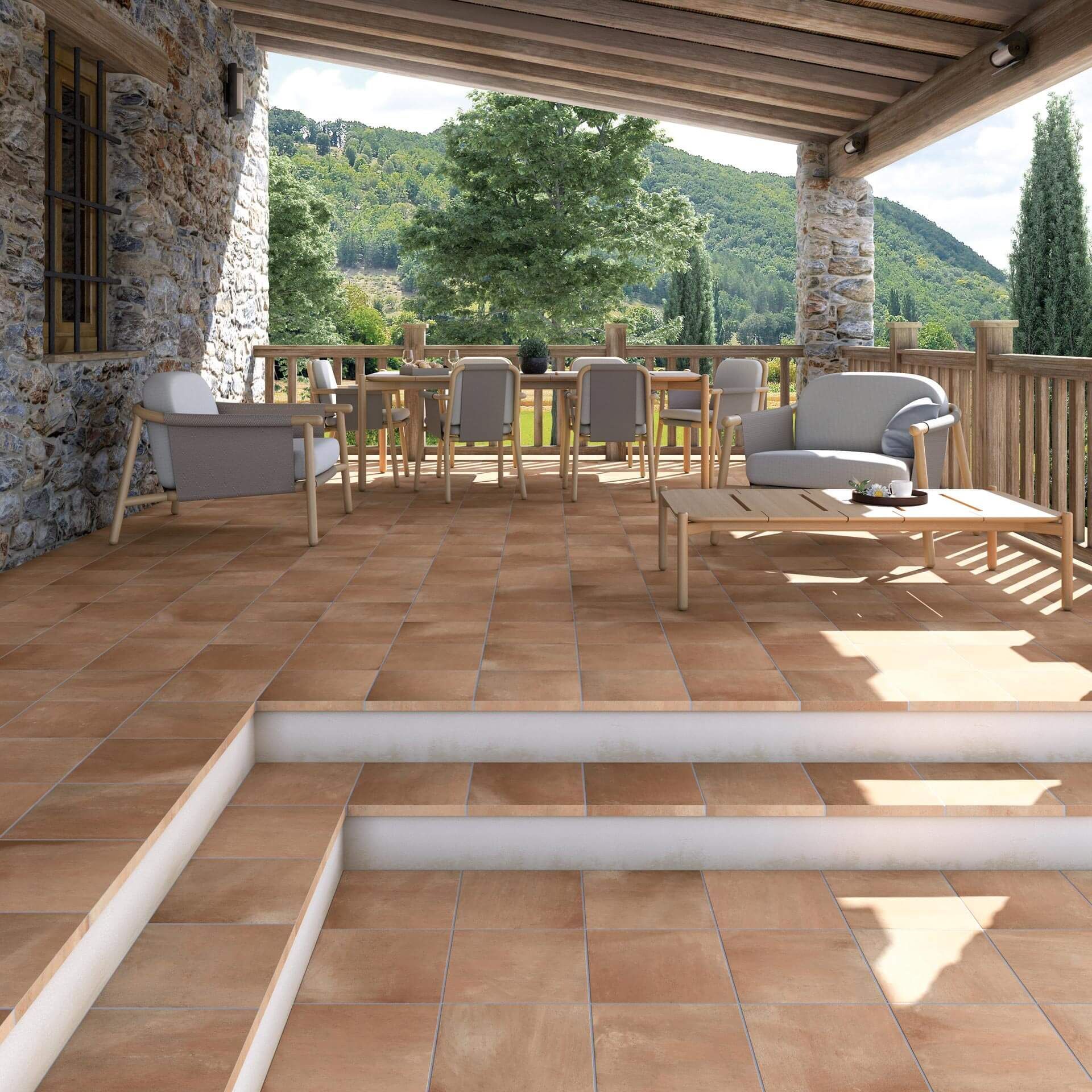 Patio con baldosas de terracota con asientos al aire libre, escalones y vista a las montañas.