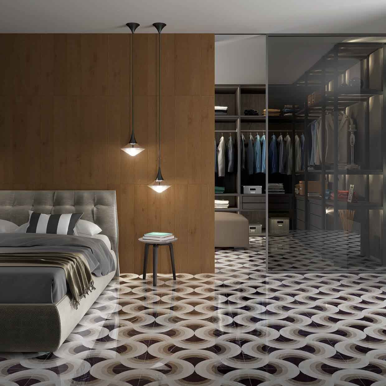 Dormitorio con cama, mesa pequeña y armario abierto; piso de baldosas estampadas, pared con acento marrón y luces colgantes.