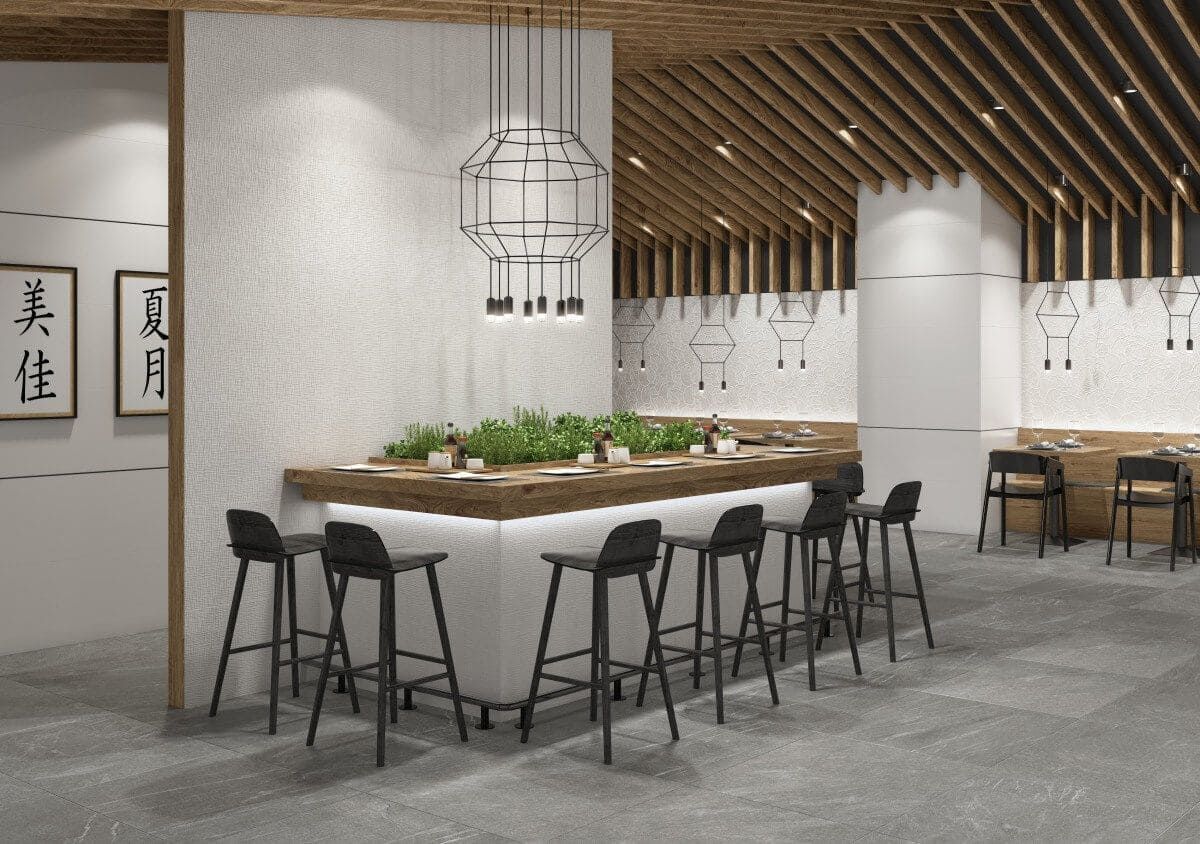 Interior de restaurante moderno con asientos de barra, iluminación cenital y detalles de madera en el techo.