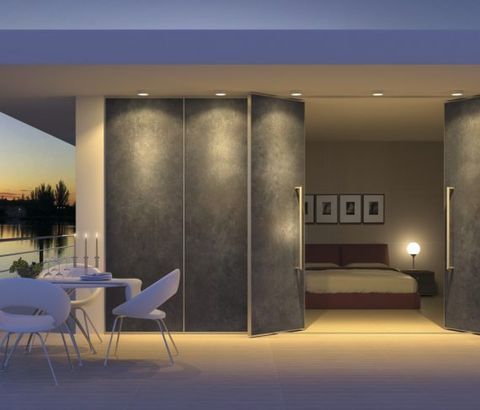 Patio de dormitorio con puertas plegables: escena nocturna, puertas gris oscuro, sillas blancas, vista del atardecer.