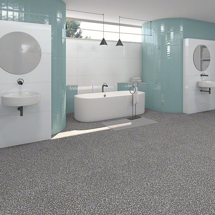 Baño moderno con paredes blancas, bañera, lavabos y detalles en turquesa. Suelo moteado gris.