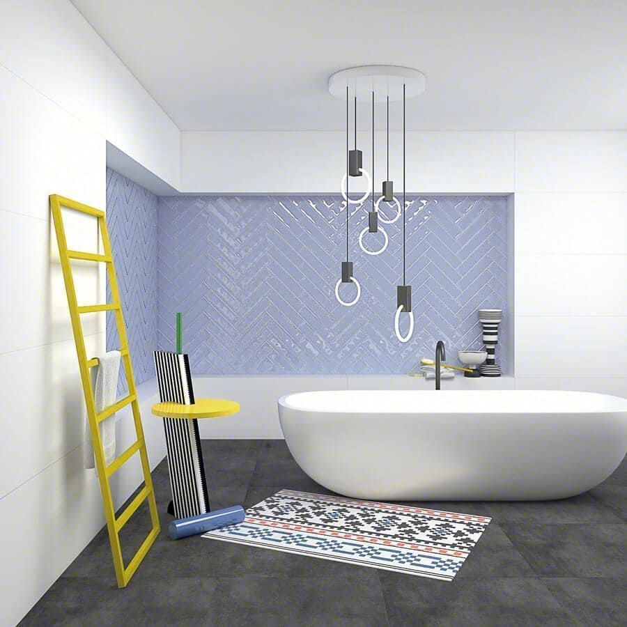 Baño moderno con bañera blanca, pared con acento azul, escalera amarilla y lámpara única.