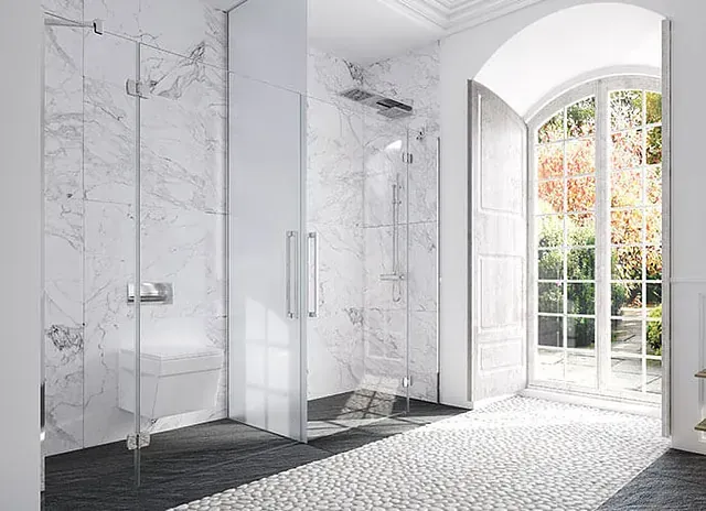 Baño moderno con ducha de cristal, paredes de mármol y un gran ventanal con vistas a un jardín.