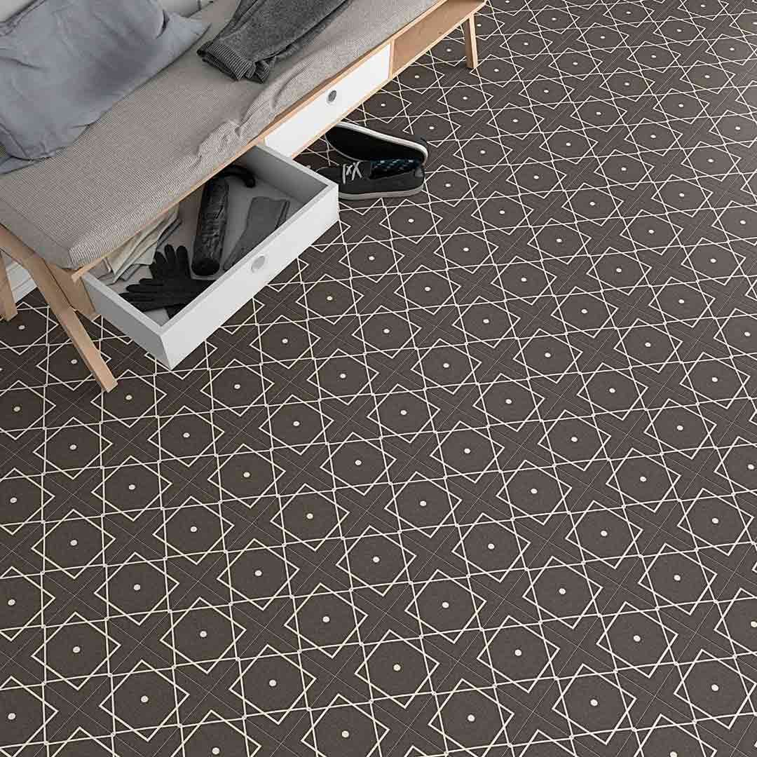 Suelo de diseño geométrico oscuro con dibujos dorados, junto a un banco con cajón abierto que contiene objetos.