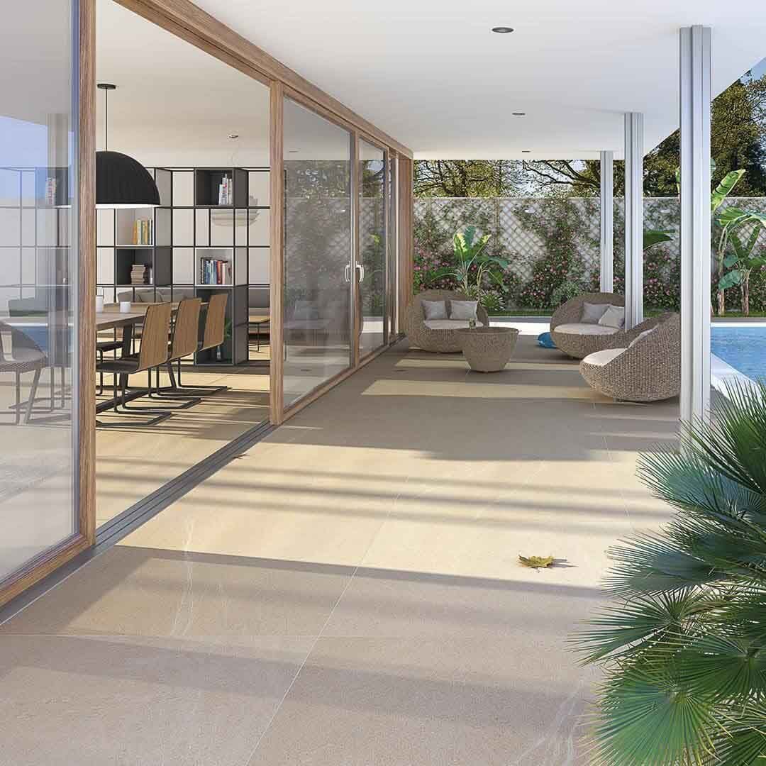 Patio con puertas corredizas de vidrio, con vista a la piscina. Amueblado con asientos y comedor interior.