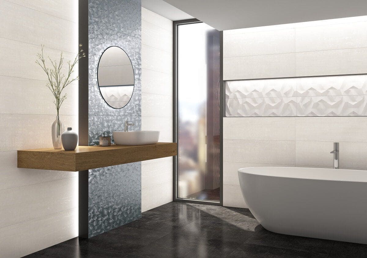 Baño moderno con azulejos blancos y azules, estante flotante de madera, espejo ovalado y bañera independiente.