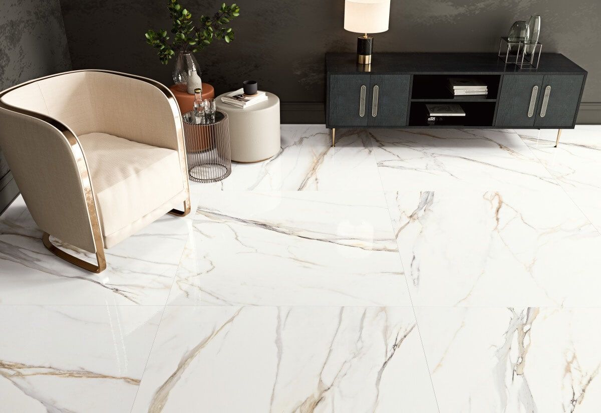 Suelo de mármol blanco con vetas doradas; sillón, mueble y decoración.